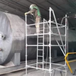 Operario de Alquiser aplicando sandblasting a un tanque cilíndrico de 500 barriles